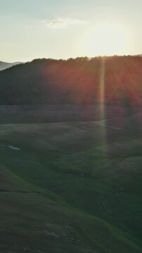 Golden Sunset Rays Over Mountains and Dry Dam Landscape