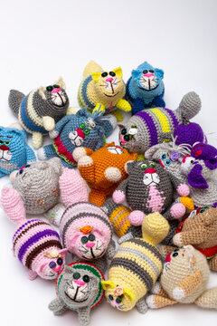 Several knitted woolen cats and dogs on a white background