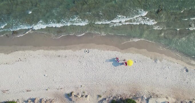 Aerial View of Couple with Yellow Umbrella on Halkidiki Beach