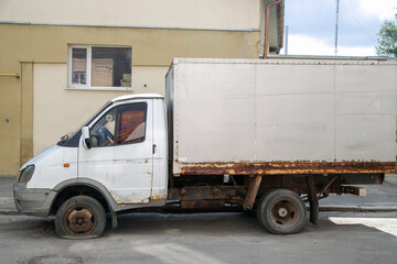 Broken white delivery van with rust and flat front tire © Валентина Хруслова