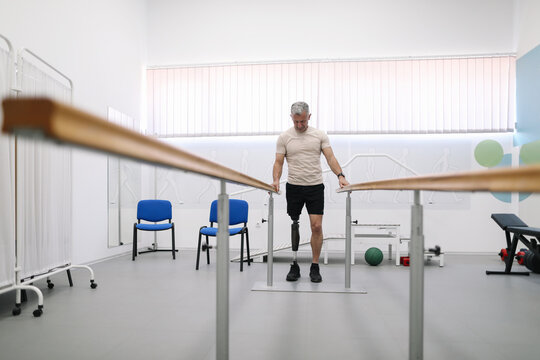 An amputee test his prosthesis during a prosthetic fitting session