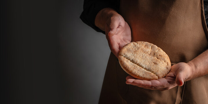 Baker Holding Fresh Pita Bread with Copy Space