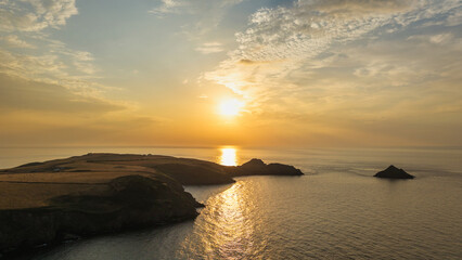 Fototapeta premium Beautiful drone landscape image of Pentire Headland and The Rumps in Cornwall and surrounding countryside during colorful Summer sunset
