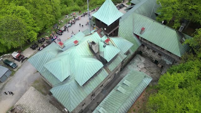 Summer aerial view of the iconic stone mountain refuge with green roof, outdoor terrace, hikers and mountain landscapes in southern Poland.