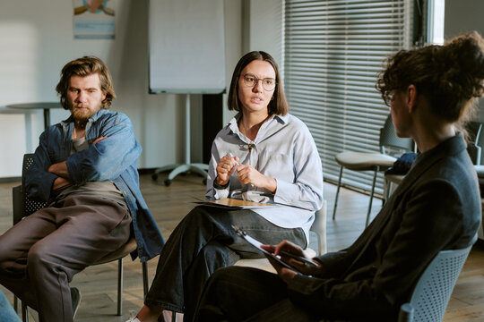 Young adult therapy group discussing emotions during counseling session, supporting mental health recovery and peer connection. Ideal for wellness, addiction, trauma, support campaigns