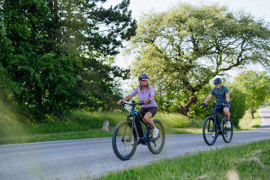 Active senior couple exploring nature on electric bicycles