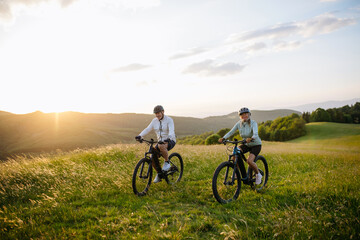 Fototapeta premium Active senior couple exploring nature on electric bicycles