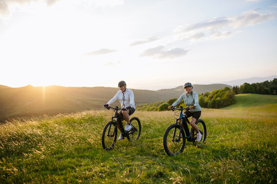 Active senior couple exploring nature on electric bicycles