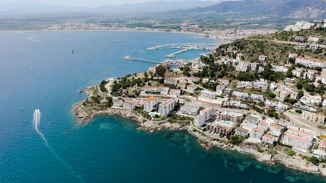Aerial view of Roses Harbor and the historic Castell de la Trinitat, overlooking the Mediterranean Sea and the surrounding landscapes of the Costa Brava, Girona. 