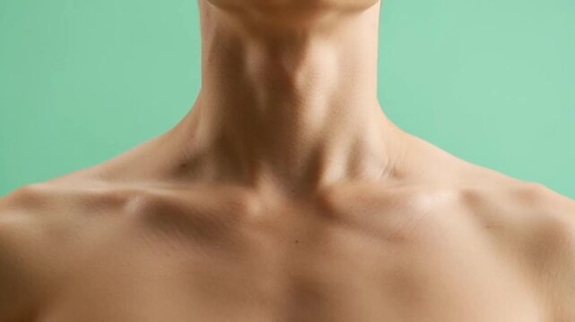 Close up view of a person with a visible thyroid gland area on a green background.