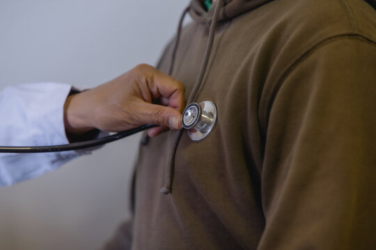 Doctor examining patient with stethoscope during routine medical checkup in a modern clinic. Healthcare, physical examination, preventive medicine