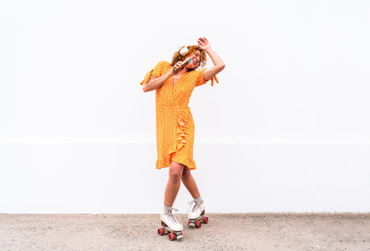 Beautiful red haired young woman with rollerskates having fun outdoors