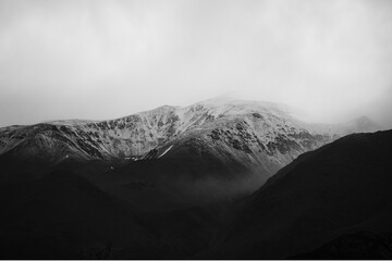 Snow-capped mountain landscape with cloudy sky. Majestic natural scenery for travel and outdoor themes. © Ali Ahmad