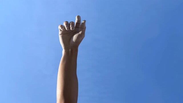 raised hands celebrating success against clear blue sky with energetic and uplifting mood top-down perspective commercial natural light clean background copy space modern bright warm cool.