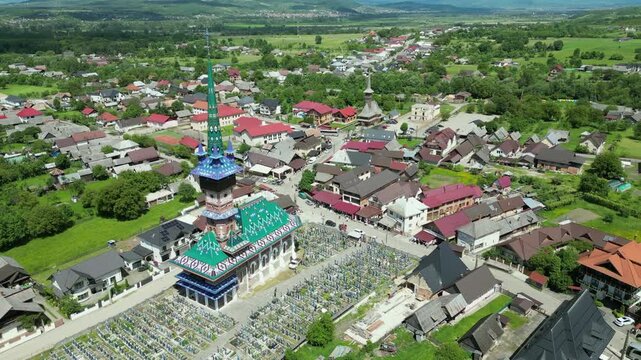 Drone view of the Merry Cemetery, a famous open air museum in Sapanta, Maramure. Colorful tombstones and a traditional wooden church