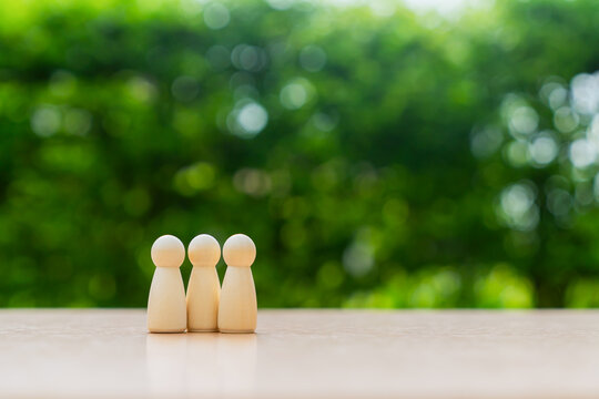 Wooden family figures on table with green background
