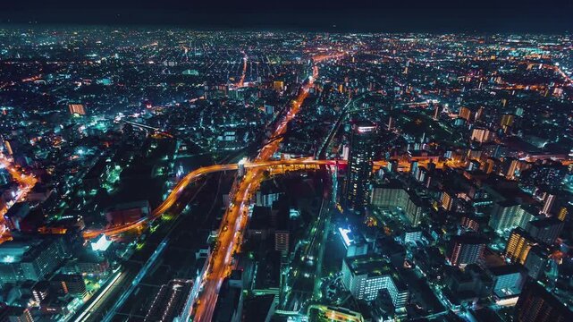 Osaka City Nighttime Aerial Timelapse Capturing Vibrant Glowing Traffic Light Trails Along Urban Expressways and Dense Metropolitan High Rise Skyscrapers in 4k Resolution