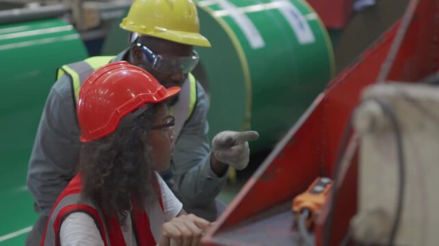 The foreman is training the employees to operate the machinery in the factory.