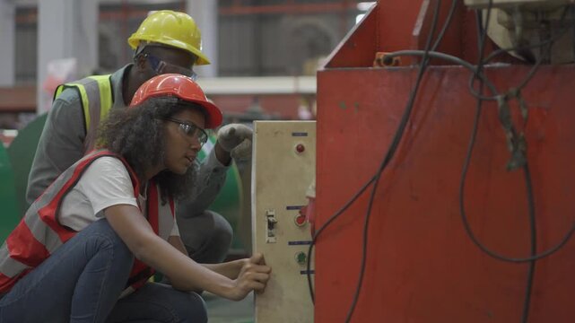 The foreman is training the employees to operate the machinery in the factory.