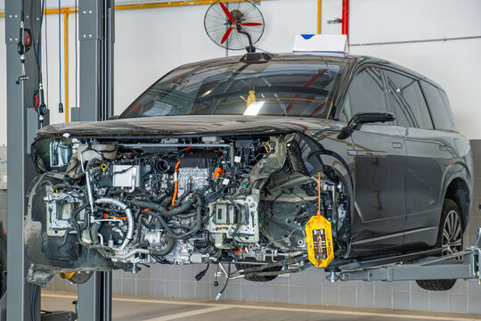 Electric vehicle undergoing maintenance in modern automotive service center. Professional vehicle diagnostics, repair, electric mobility infrastructure with advanced automotive technology