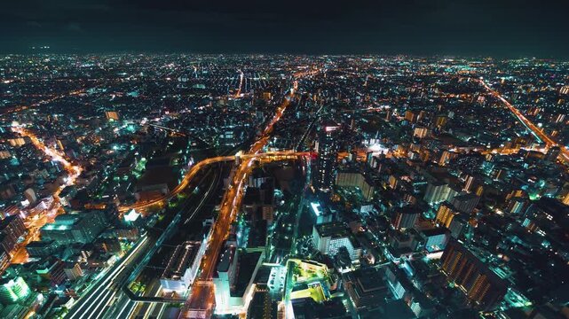Osaka City Skyline Night Timelapse Aerial View Featuring Glowing Highway Light Trails and Dense Urban Infrastructure in 4k High Definition Resolution High Angle Perspective