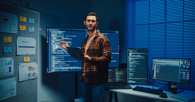 Confident Caucasian male engineer presents software strategy during late night work in office. Experienced tech consultant expertise, Innovative startup leader, Professional online conference concept.