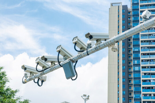 Multiple surveillance cameras installed above modern city street in Shenzhen, China. Smart city infrastructure, public safety, urban security, traffic monitoring, digital surveillance