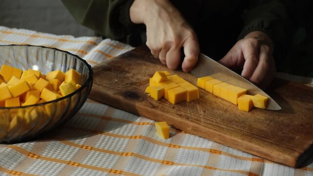 Woman slicing pumpkin. Preparing autumn food. Cooking pumpkin soup