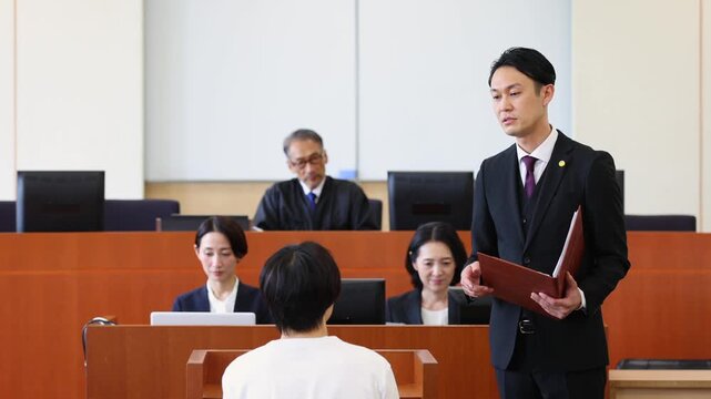 法廷で証人尋問を行う弁護士