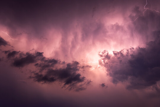Thunderstorm, discharges in the night sky, clouds illuminated by a flash.