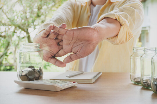 Person Stretching Hands During Financial Planning Break, Home Workspace, Calculator Notebook Coffee and Savings Jar Promoting Work Life Balance Productivity Financial Wellness, Healthy Office Routine