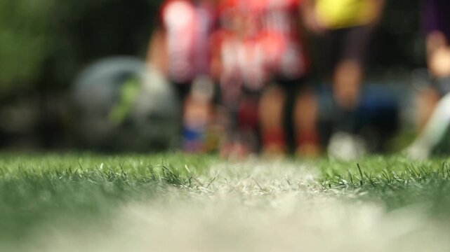 Football field in sharp focus with players training in the background creating a professional sports atmosphere for competition and practice in 4K 