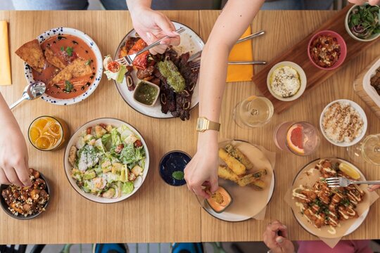 A diverse spread of colorful dishes captures a festive gathering at a trendy restaurant