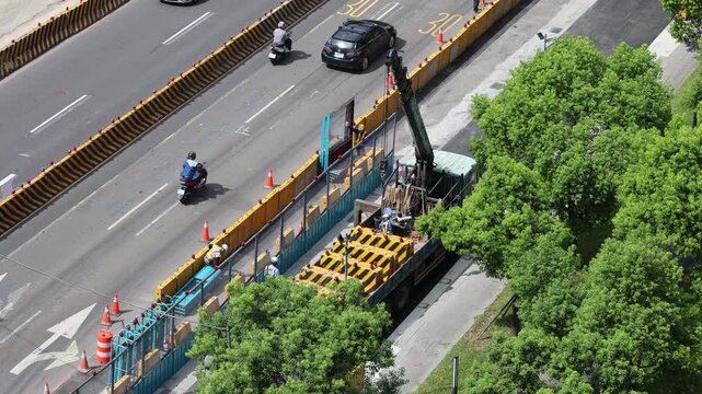 High angle view of road construction workers and crane truck on city street, 4K b-roll
