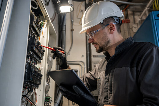 Licensed electrician inspects residential electrical panel, testing circuit breakers and reviewing diagnostics to support electrical safety, preventive maintenance and professional service.