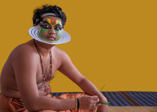 Kathakali dancer waiting for the next phase of makeup to be done. 