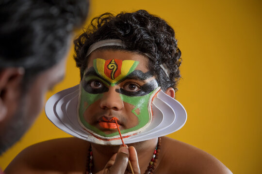 Kathakali dancer getting his final stages of makeup done.
