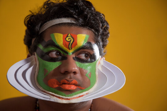 Kathakali dancer in front of a yellow background 