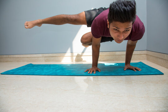 Man doing advanced yoga exercises at home. 