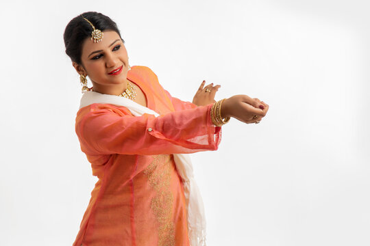 Graceful kathak dancer performing over a white background. 
