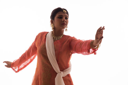 Graceful Kathak dancer giving a mesmerising performance in front of a white background. 