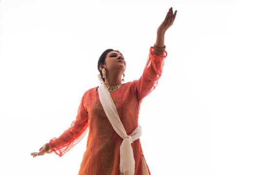 Graceful Kathak dancer giving a mesmerising performance in front of a white background. 
