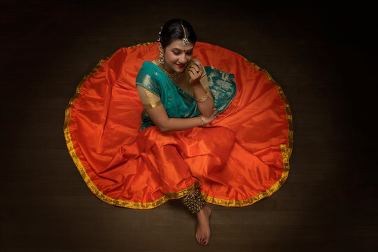 Kathak dancer sitting gracefully on the floor. 