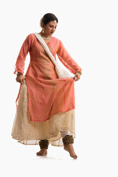 Graceful Kathak dancer giving a mesmerising performance in front of a white background. 