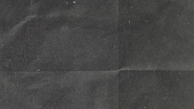 Abstract dark gray grunge paper texture with subtle folds and vintage paper grain overlay.