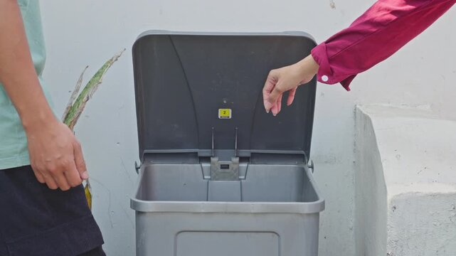 People throwing broken smartphone screens and circuit boards into dedicated e-waste bin