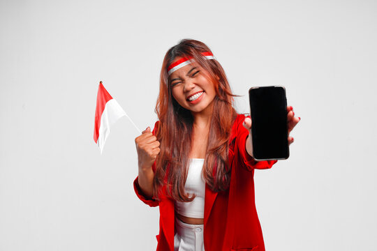 Excited young Indonesian woman presenting smartphone with a happy successful expression.