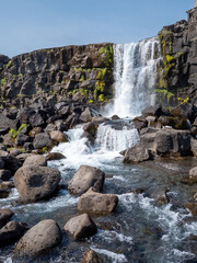 Beautiful Icelandic waterfall cascading over rugged volcanic rocks into a clear mountain stream. © Anastasia