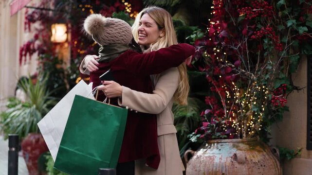 Video of two beautiful female friends hugging on the city streets in winter.