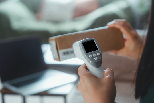 Barcode Scanner Reading Package Label, Online Seller Processing Ecommerce Order Beside Laptop, Inventory Management, Shipping, Logistics, Delivery Tracking And Small Business Technology